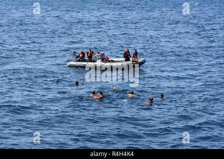 Golf von Aden (Sept. 30, 2018) Matrosen an Bord eines starren Hülle Schlauchboot bieten Life guard Unterstützung während Segler genießen Sie einen Anruf Schwimmen während der Fahrt an Bord der USS Lewis B. Abzieher (ESB3). Die expeditionary Meer base Plattform unterstützt Naval Amphibious Force, Task Force 51, diverse Missionen des 5. Marine Expeditionary Brigade, Krisenbewältigung, Airborne mine Gegenmaßnahmen gehören, Bekämpfung der Piraterie Betrieb, Maritime Security Operations und humanitäre Hilfe/Katastrophenhilfe Missionen. Gleichzeitig ermöglicht sie eine TF 51/5 seine Flüchtigen expeditionary Präsenz in den meisten Regionen der Welt zu erweitern. Stockfoto