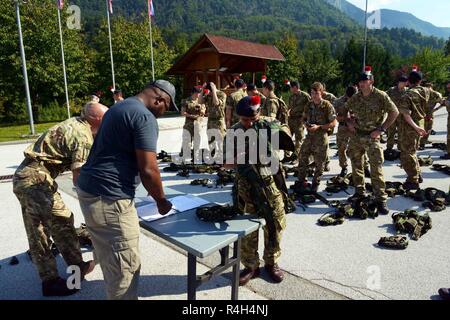 Vereinigtes Königreich Soldaten zurück Dise einsetzbaren Instrumentation Systems Europe (DISE) sytem Ausrüstungen nach dem Training Überprüfung des Triglav Star IV Übung, Bohinisja Bela, Slowenien, Sept. 20, 2018. Übung Triglav Star IV ist eine jährliche multi-nationalen Berg Kriegsführung Übung veranstaltet von der slowenischen Streitkräfte in Bohinjska Bela, Slowenien und ist eine intensive, zwei Wochen taktische Übung, in der Soldaten aus Großbritannien und den 1-157 in Colorado, und Slowenien Interoperabilität demonstrieren, während die Einheit Taktik in den Julischen Alpen. Stockfoto