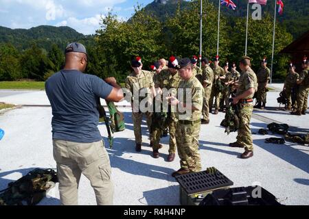 Vereinigtes Königreich Soldaten zurück Dise einsetzbaren Instrumentation Systems Europe (DISE) sytem Ausrüstungen nach dem Training Überprüfung des Triglav Star IV Übung, Bohinisja Bela, Slowenien, Sept. 20, 2018. Übung Triglav Star IV ist eine jährliche multi-nationalen Berg Kriegsführung Übung veranstaltet von der slowenischen Streitkräfte in Bohinjska Bela, Slowenien und ist eine intensive, zwei Wochen taktische Übung, in der Soldaten aus Großbritannien und den 1-157 in Colorado, und Slowenien Interoperabilität demonstrieren, während die Einheit Taktik in den Julischen Alpen. Stockfoto