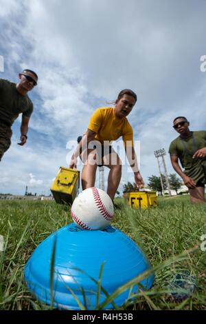 U.S. Navy Petty Officer 3rd Class Emily Pall, Okinawa gemeinsame Erfahrung Green Team Student, legt Munition Dosen und bereitet einen Baseball während der Okinawa gemeinsame Fitness Herausforderung Sept. 26, 2018 zu werfen, bei Kadena Air Base, Japan. Während die Herausforderung, waren die baseballs verwendet Granaten zu simulieren. Teams wurden abgezogen Punkte auf die Genauigkeit Ihrer wirft. Stockfoto