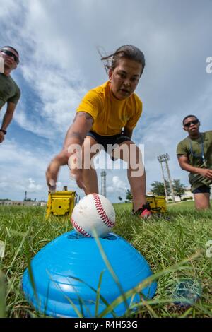 U.S. Navy Petty Officer 3rd Class Emily Pall, Okinawa gemeinsame Erfahrung Green Team Student, Reichweiten für einen Baseball während der Okinawa gemeinsame Fitness Herausforderung Sept. 26, 2018, bei Kadena Air Base, Japan. Während die Herausforderung, waren die baseballs verwendet Granaten zu simulieren. Teams wurden abgezogen Punkte auf die Genauigkeit Ihrer wirft. Stockfoto