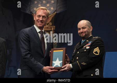 Us-stellvertretender Verteidigungsminister setzt U.S. Army Staff Sgt. Ronald J. Shurer II in der Halle der Helden im Rahmen einer Zeremonie in das Pentagon in Washington, D.C., am Okt. 2, 2018, nachdem die Ehrenmedaille verliehen wird durch den Präsidenten. Stockfoto