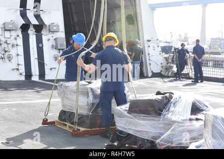 Besatzungsmitglieder der Coast Guard Cutter Stratton bereit, eine Kaution von Kokain aus der Stratton für Transfer in San Diego, Kalifornien, 3. Oktober 2018 aufgehoben werden. Die Drogen wurden während des Verbots von acht Verdacht auf Schmuggel Schiffe beschlagnahmt Weg gefunden die Küsten von Mexiko, Zentral- und Südamerika durch die Coast Guard Cutter Stratton (WMSL-752), Seneca (WMEC-906) und aktive (WMEC-618). Stockfoto