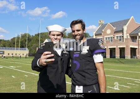 BALTIMORE (Okt. 3, 2018) der Maschinist Mate (Waffen) 3. Klasse Conor Johnson, mit der Ohio-Klasse von ballistischen Raketen-U-Boot USS Maryland (SSBN 738), nimmt eine selfie mit Joe Flacco, Quarterback für die Baltimore Ravens, während einer Tour durch die Raben' Praxis Feld an die Under Armour Performance Center als Teil von Maryland Fleet Week Air Show und Baltimore. MDFWASB ist Baltimore's Feier der sea Services und bietet die Möglichkeit für die Bürgerinnen und Bürger von Maryland und der Stadt Baltimore zu treffen Seemänner, Marinesoldaten und Küstenwache, sowie Sie aus erster Hand, die Möglichkeiten von heute' Stockfoto