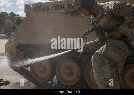 Spc. Dunson Darious an 2nd Battalion, 69th Armored Regiment, 2. gepanzerte Brigade Combat Team, reinigt die Tracks auf seine zugewiesene M113 Schützenpanzer in Fort Stewart, Ga., Okt. 3, 2018. Soldaten, saubere Fahrzeuge als Teil der regelmäßigen Wartung und Pflege der Ausrüstung. Stockfoto