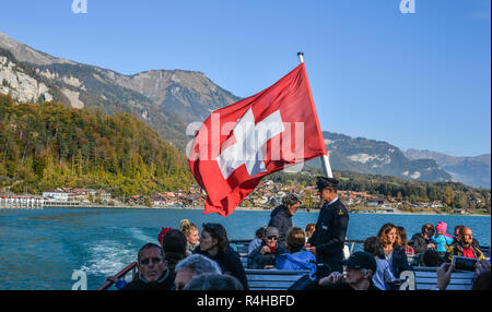 Interlaken, Schweiz - 21.Oktober 2018. Schweizer Flagge von touristischen Fähre auf dem See in Interlaken, Schweiz. Stockfoto