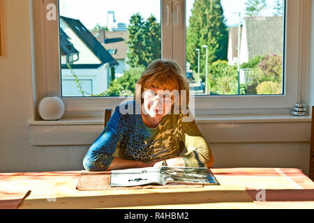 Ältere Menschen attraktive Frau zu Hause in einer Zeitschrift Stockfoto