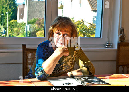 Ältere Menschen attraktive Frau zu Hause in einer Zeitschrift Stockfoto