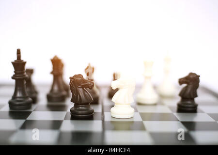 Foto von Schach schwarze und weiße Bauern auf dem Schachbrett Spiel. Auf den weißen Hintergrund isoliert. Stockfoto
