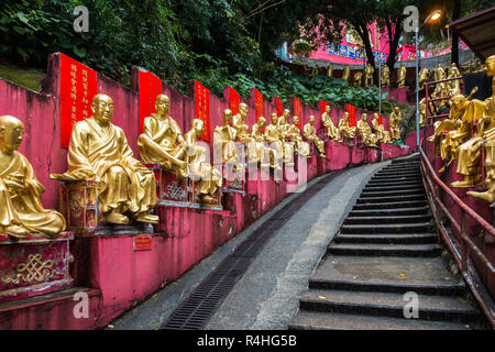 Buddha Statuen entlang den steilen Weg zum Kloster von Zehn Tausend Buddhas, die jeweils mit unterschiedlichen Posen, Hong Kong, Sha Tin, neue Gebiete Stockfoto