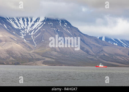 Landschaftlich schöne Ansicht mit Norge Kreuzfahrt Schiff angedockt in Longyearbyen Hafen vor dem Hintergrund der Eingenebelt Black Mountain und ruhigen Wasser des Advents Bay, Spitzbergen (Svalbard), Norwegen, Grönland Meer Stockfoto