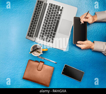 Geschäftsmanns, der mit digitalen Tablet-PC, Laptop, Handy auf Büro Schreibtisch. Ansicht von oben Stockfoto