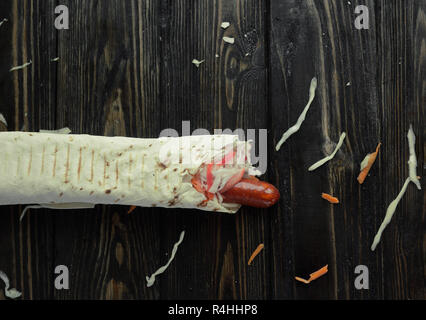 Würstchen und Salat eingewickelt in lavash auf hölzernen Hintergrund. Foto Stockfoto