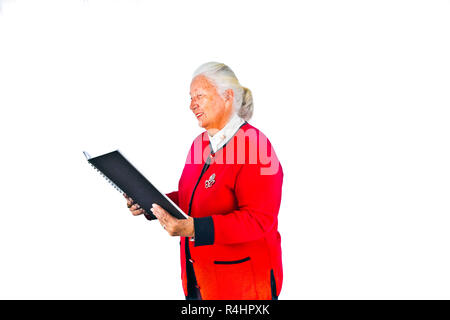 Lächelnd attraktive ältere Frau in einem Buch lesend und eine Rede Stockfoto