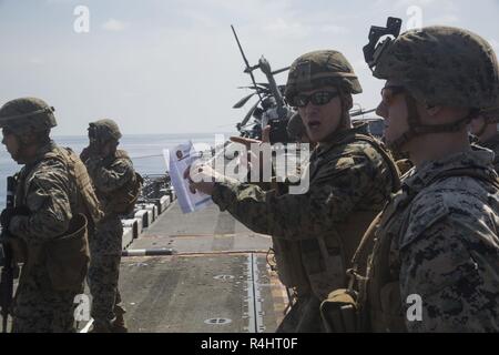 Staff Sgt. Dallas Allen, der platoon Sergeant für Unternehmen F, Bataillon Landung Team, 2nd Battalion, 5th Marines, beauftragt Marines während der Treffsicherheit der Ausbildung an Bord der Amphibisches Schiff USS Wasp (LL 1), unterwegs in das Südchinesische Meer, Sept. 30, 2018. Allen, ein Eingeborener von Gloucester, Virginia, graduierte Gloucester High School, Juni 2005; er im Juni 2007 eingetragen. Während der Fahrt, Marines Verhalten live-fire Übungen auf dem Flugdeck und Hangar bay Treffsicherheit Taktiken und Techniken zu verfeinern. Die 31. MEU, das Marine Corps' nur kontinuierlich vorwärts - bereitgestellt MEU, bietet eine fle Stockfoto