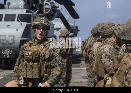 Staff Sgt. Dallas Allen, der platoon Sergeant für Unternehmen F, Bataillon Landung Team, 2nd Battalion, 5th Marines, beauftragt Marines während der Treffsicherheit der Ausbildung an Bord der Amphibisches Schiff USS Wasp (LL 1), unterwegs in das Südchinesische Meer, Sept. 30, 2018. Allen, ein Eingeborener von Gloucester, Virginia, graduierte Gloucester High School, Juni 2005; er im Juni 2007 eingetragen. Während der Fahrt, Marines Verhalten live-fire Übungen auf dem Flugdeck und Hangar bay Treffsicherheit Taktiken und Techniken zu verfeinern. Die 31. MEU, das Marine Corps' nur kontinuierlich vorwärts - bereitgestellt MEU, bietet eine fle Stockfoto