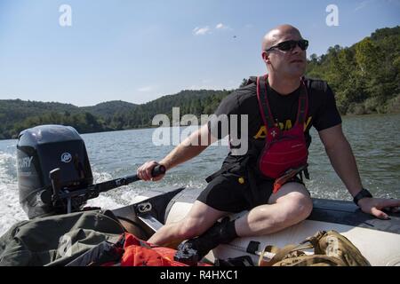 Mitglieder der West Virginia Swift Wasser Rescue Team (WVSWRT) Geschwindigkeit über Buche See in ein Soldat von 2 Bataillon in Hebezeug 19 Special Forces Group (Airborne) Sept. 21, 2018 in Huntington, W. Virginia. Die 2/19 th Soldaten abgeschlossen statische Linie Fallschirm Ausbildung Kenntnisse in der Luft. Stockfoto