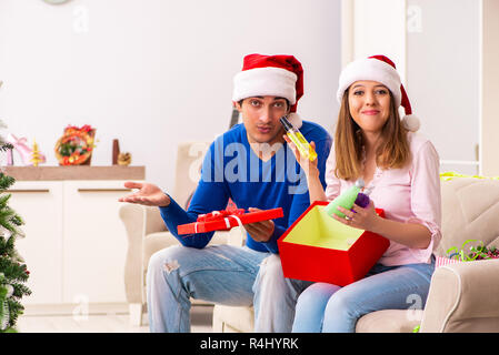 Junges Paar Weihnachten zu Hause feiern. Stockfoto