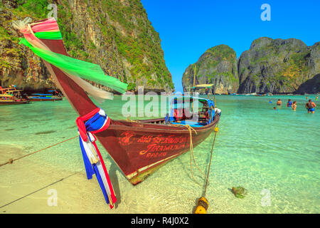 Maya Bay, Phi Phi Leh, Thailand - 31. Dezember 2015: Beliebte paradiesischen Strand Maya Bay auf Ko Phi Phi Leh mit bunten long tail Boot und Kalkstein Hügel im Hintergrund. Thailändische Inseln in der Andaman See. Stockfoto