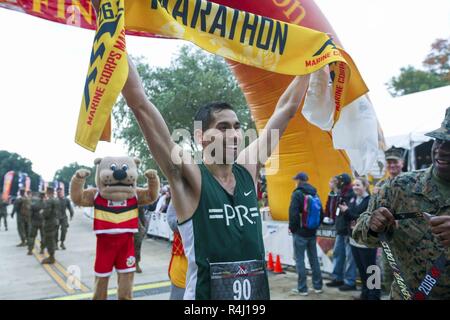 Jeffrey Stein, ersten männlichen Finisher der 43rd Marine Corps Marathon, hält die Fahne, Arlington, Va., Nov. 28, 2018. Stein beendete das Rennen in zwei Stunden und 22 Minuten. Stockfoto