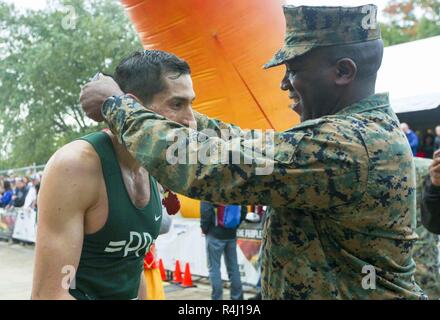 Us Marine Corps Sgt. Maj. Ronald L. Grün, Sergeant Major des Marine Corps, Orte Medaille um Jeffrey Stein am Hals, ersten männlichen Finisher der 43rd Marine Corps Marathon, Arlington, Va., Nov. 28, 2018. Stein beendete das Rennen in zwei Stunden und 22 Minuten. Stockfoto