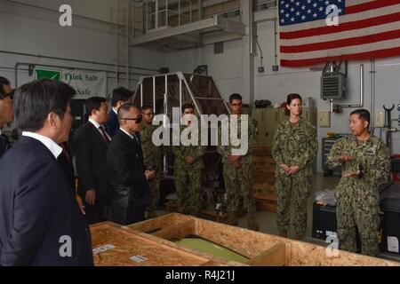 YOKOSE, Japan (29. Oktober 2018) Cmdr. Greta Densham, kommandierender Offizier der Marine Beach (NBU) 7, und Chief Warrant Officer wird Dispolo, maintenance Officer der NBU7, mit Nagasaki Prefectural Assembly Rat Mitglieder sprechen am Yokose Landing Craft air cushion (LCAC). Mitglieder des Rates wurden der Yokose Einrichtung für eine Lcac kurze, Facility Tour eingeladen, und LCAC Operationen zu beobachten. NBU 7 dient als Trainings- und Befehl Bereitschaft für LCACs, Landing Craft Dienstprogramme und Beach party Teams freuen sich - in Japan eingesetzt. Stockfoto