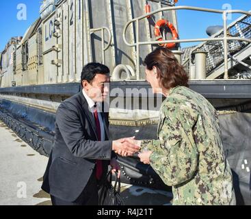 YOKOSE, Japan (29. Oktober 2018) Cmdr. Greta Densham, kommandierender Offizier der Marine Beach (NBU) 7, schüttelt Hände mit einem Nagasaki Prefectural Assembly Rat Mitglied am Yokose Landing Craft air cushion. Mitglieder des Rates wurden der Yokose Einrichtung für eine Lcac kurze, Facility Tour eingeladen, und LCAC Operationen zu beobachten. NBU 7 dient als Trainings- und Befehl Bereitschaft für LCACs, Landing Craft Dienstprogramme und Beach party Teams freuen sich - in Japan eingesetzt. Stockfoto