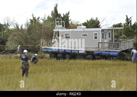 Coast Guard Petty Officer 3rd Class Seth Grayson, einem Marine science Techniker Marine Safety Unit Portland, Erz zugeordnet, beaufsichtigt die Entfernung von einem Hausboot auf den Rachel Carson finden, einen dedizierten Nature Preserve, Carteret County, N.C., Samstag, Oktober 27, 2018 vertrieben wurde. Der ESF-10 Unified Befehl, der aus der US-Küstenwache, Nord-Carolina Wildnis-Betriebsmittel-Kommission und North Carolina Department Umwelt Qualität, zusammen mit der Bergung Auftragnehmer Marine lösen Gruppe und mehrere Agenturen unterstützen die Verschmutzung von versunkenen oder vertriebenen Schiffe zu mildern i Stockfoto