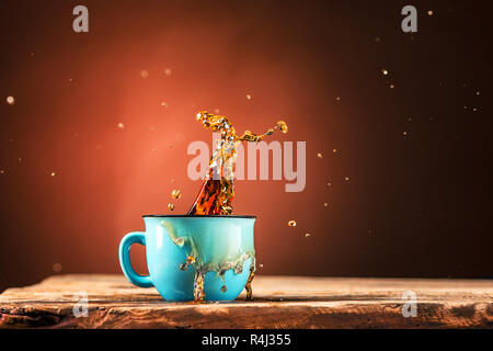 Braune Spritzer, Trinken aus der Tasse Tee auf einem braunen Hintergrund Stockfoto