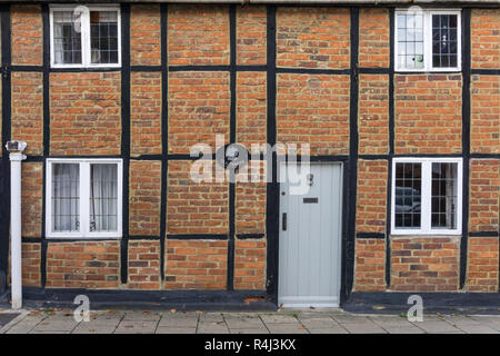 Alte Hölzer, einem fachwerkhaus Backstein Hütte Teil eine Terrasse, eine gut Straße, Buckingham, Großbritannien Stockfoto