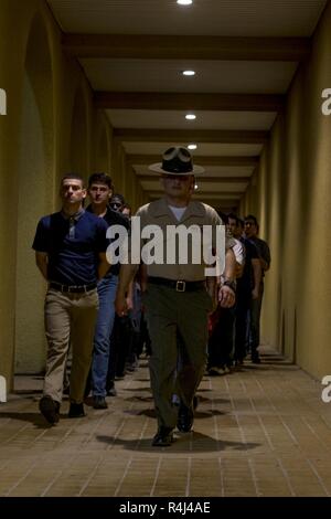 Staff Sgt. Yezio Beltran, Senior drill instructor, erhält, Escort Rekruten mit Mike Unternehmen, 3. rekrutieren Ausbildung Bataillon, die schmuggelware Zimmer während des Empfangs des Marine Corps Recruit Depot San Diego, Okt. 29. Die rekruten sind erforderlich, um jegliche Schmuggelware sie mitgebracht haben können, zu verwerfen. Jährlich mehr als 17.000 Männer aus den westlichen Recruiting Region rekrutiert werden an MCRD San Diego ausgebildet. Mike ist zu graduieren, Jan. 25 geplant. Stockfoto
