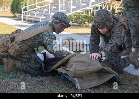 U.S. Navy Hospital Corpsman 3. Klasse Ryan Sandstrand mit 2. Medizinische Bataillon, 2. Marine Logistics Group, Links, und Hospital Corpsman 3. Klasse Victor Paturzo, rechts, 2 Med Bn, 2. MLG, bewerten eine simulierte Patent während einer im Route pflege Flug in Camp Lejeune, N.C., Okt. 30, 2018. 2. Med Mrd. statt der Schulungsveranstaltung zu ermöglichen Matrosen Betriebsbereitschaft aufrecht zu erhalten und die Bekämpfung der Bereitschaft zu stärken. Stockfoto