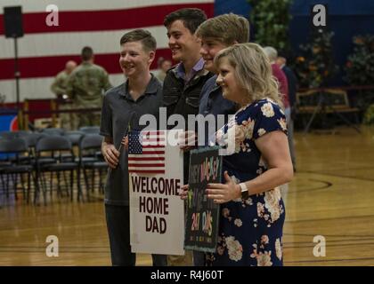 Die basham Familie halten Schilder für Ihre Soldaten, Cpt. Mickey Basham, der Kaplan mit der 2 Infantry Brigade Combat Team, während ein homecoming Zeremonie, Oktober 31, 2018, an der William Bill Reed Special Events Center, Fort Carson, Colorado statt. Die 2 IBCT, 4 Infanterie Division im Einsatz in Afghanistan die entschlossene Unterstützung der Durchführung von Zug, beraten und Maßnahmen, die es ermöglichen, der afghanischen nationalen Verteidigungs- und Sicherheitskräfte Sicherheit und Stabilität zu erhöhen, um die terroristischen sicheren Häfen zu verhindern, unterstützen. Zusätzlich ein Bataillon bereitgestellt für den Kosovo zur Unterstützung von Multinatio Stockfoto