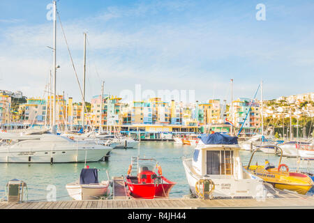 Sportboote am Jachthafen von Albufeira mit pastellfarbenen postmodernen Ferienwohnung Bausteine im Hintergrund Stockfoto