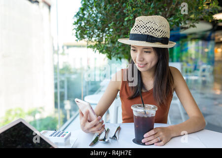 Frau mit Handy in Coffee Shop Stockfoto