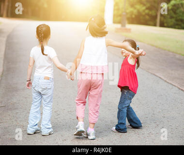 Asiatische Kinder halten sich an den Händen wandern Outdoor. Stockfoto