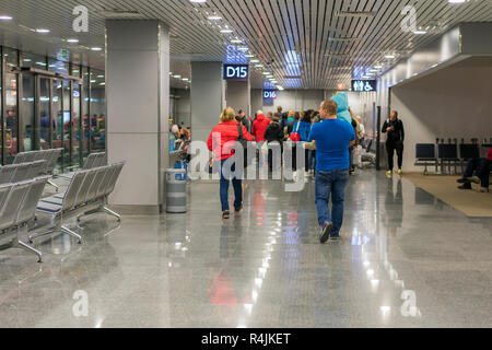 Reisende mit Koffern zu Fuß durch den Flughafen. Passagiere Spaziergang durch den Flughafen. Stockfoto