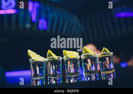 Silver tequila Schüsse mit Eis und Kalk auf Schwarzen Tisch Hintergrund. Stockfoto