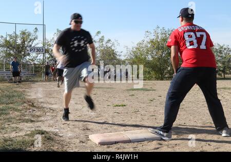 Us-amerikanische und kanadische Service Mitglieder eingesetzt zur Unterstützung der Operation Atlantic lösen ein Spiel der Softball an Mihail Kogalniceanu Air Base, Rumänien, Okt. 28, 2018 spielen. Der Service Mitglieder beteiligen sich an sportlichen Aktivitäten zusammen, die Moral zu bauen und ihre Partnerschaft verbessern. Stockfoto