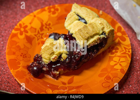 Stück der amerikanischen Torte mit Kirschen auf dem orange Glasplatte Stockfoto