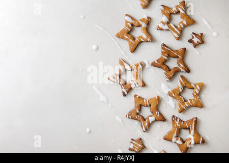 Hausgemachte Weihnachten Stern Zucker caramel Cookies mit Zuckerguss über weißem Marmor Hintergrund. Flach, kopieren. Süße Weihnachten oder Neujahr Geschenk. Stockfoto