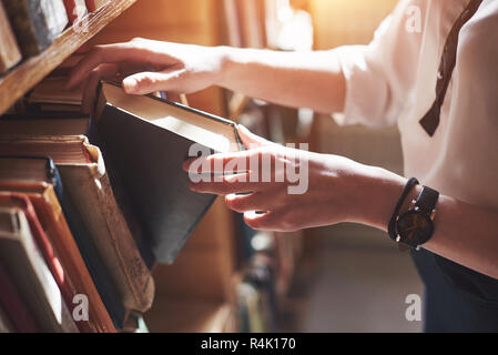 Ein junges Mädchen Student auf der Suche nach Literatur in der Nähe der Regale in der alten Bibliothek Stockfoto