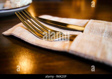 Messer und Gabel in Leinen Servietten auf dem Tisch. Stockfoto