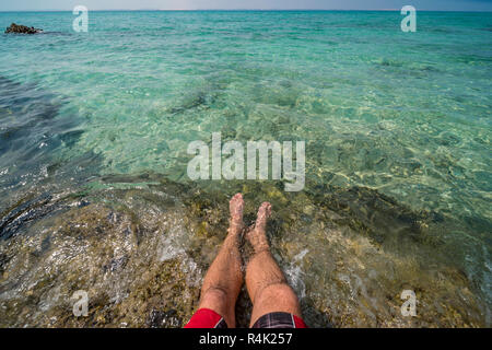 Ein Tourist testet das Wasser auf Mosambiks Paradise Island. Stockfoto