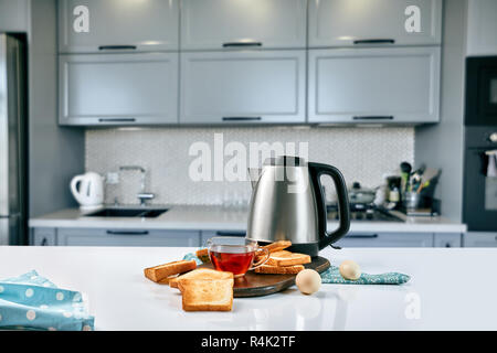 Eine Tasse schwarzer Tee mit Sandwiches oder Toasts auf weißer Tisch. Frühstück Konzept mit kopieren. Stockfoto