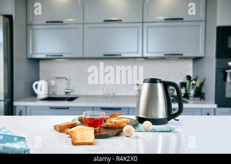 Eine Tasse schwarzer Tee mit Sandwiches oder Toasts auf weißer Tisch. Frühstück Konzept mit kopieren. Stockfoto