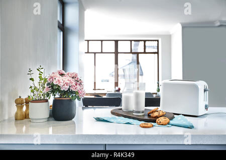 Cookies und Milch mit einem Glas Milch Flasche auf eine Arbeitsplatte in der Küche für einen Snack nach der Schule von Cookies und Milch oder Cookies und Creme. Frühstück in mornin Stockfoto