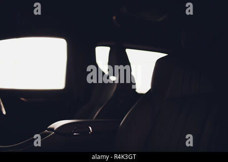 Luxus Auto innen. Innenraum der Prestige modernes Auto. Komfortable Ledersitze. Schwarz perforiertes Leder Cockpit mit isolierten schwarzen Hintergrund. Stockfoto