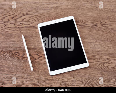 Apple Bleistift und seine Kappe über ein iPad der Farbe Weiß über eine Holz- Oberfläche Stockfoto