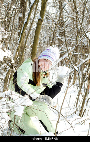 Frau im Winter Schneeball werfen Stockfoto